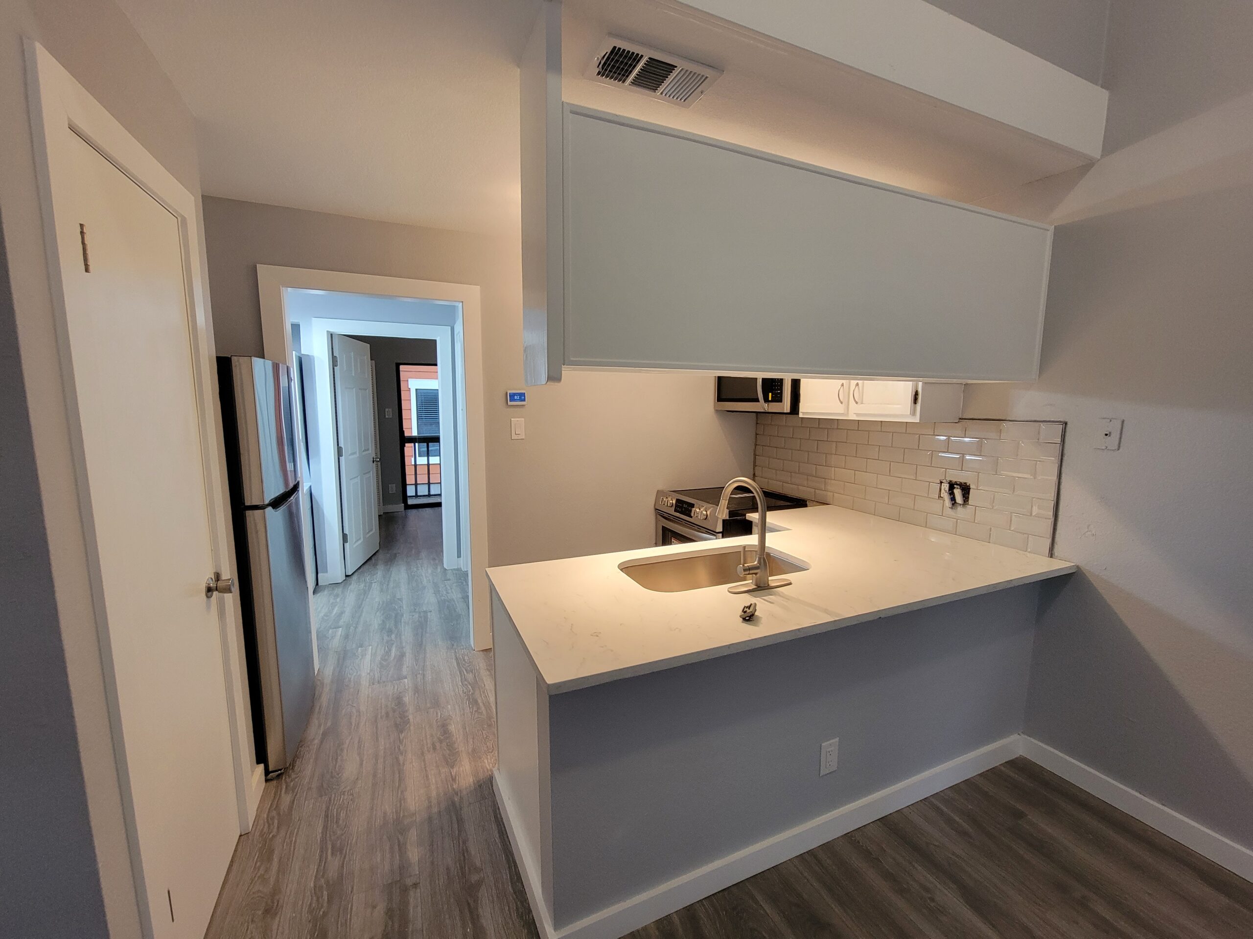Small kitchen renovation in Austin TX by Cuatro Pilares with modern countertops, backsplash, and sink installation