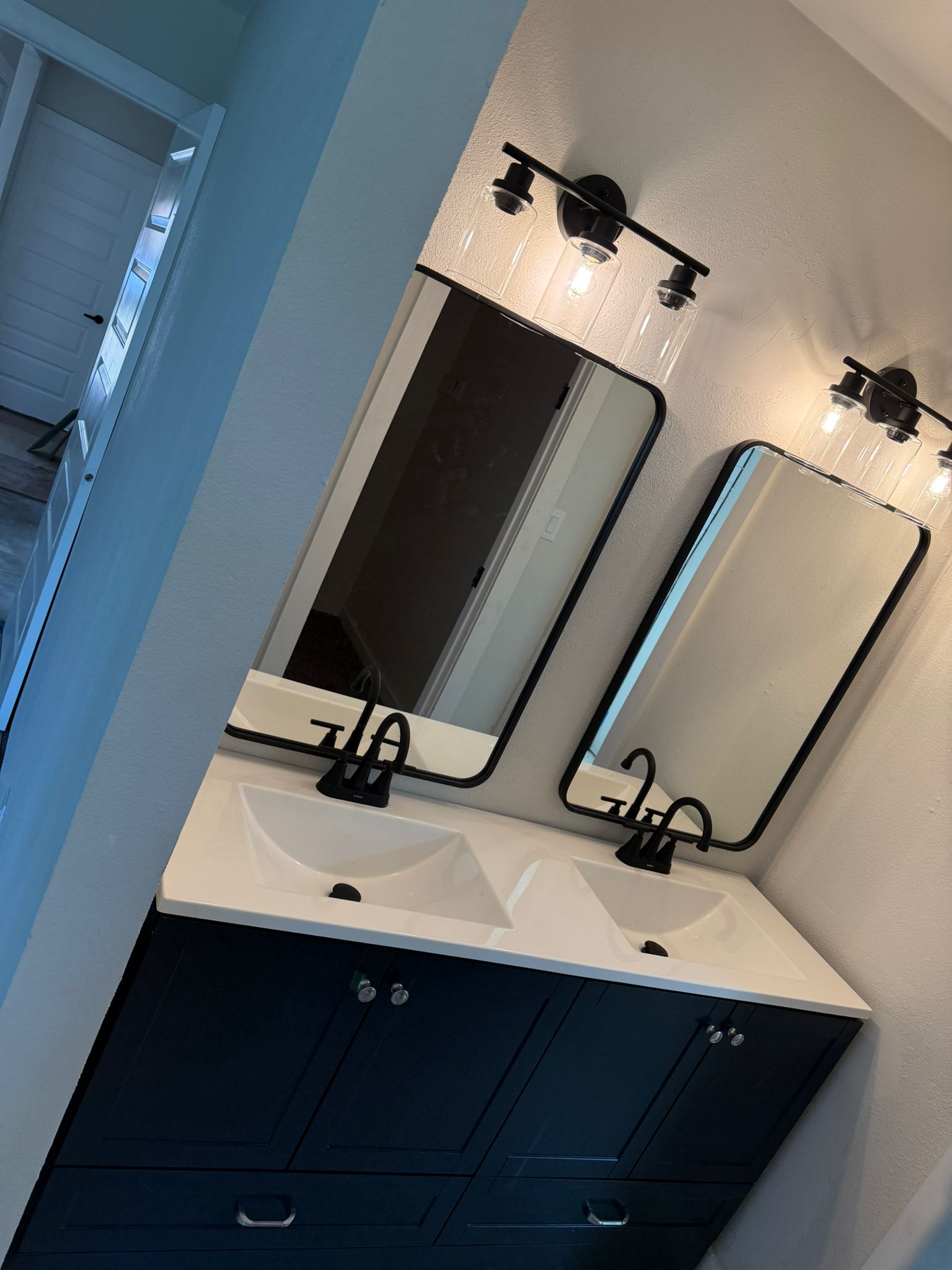 Experienced Austin TX remodeling contractor Cuatro Pilares installing modern double vanity with custom cabinetry, mirrors, and upgraded fixtures