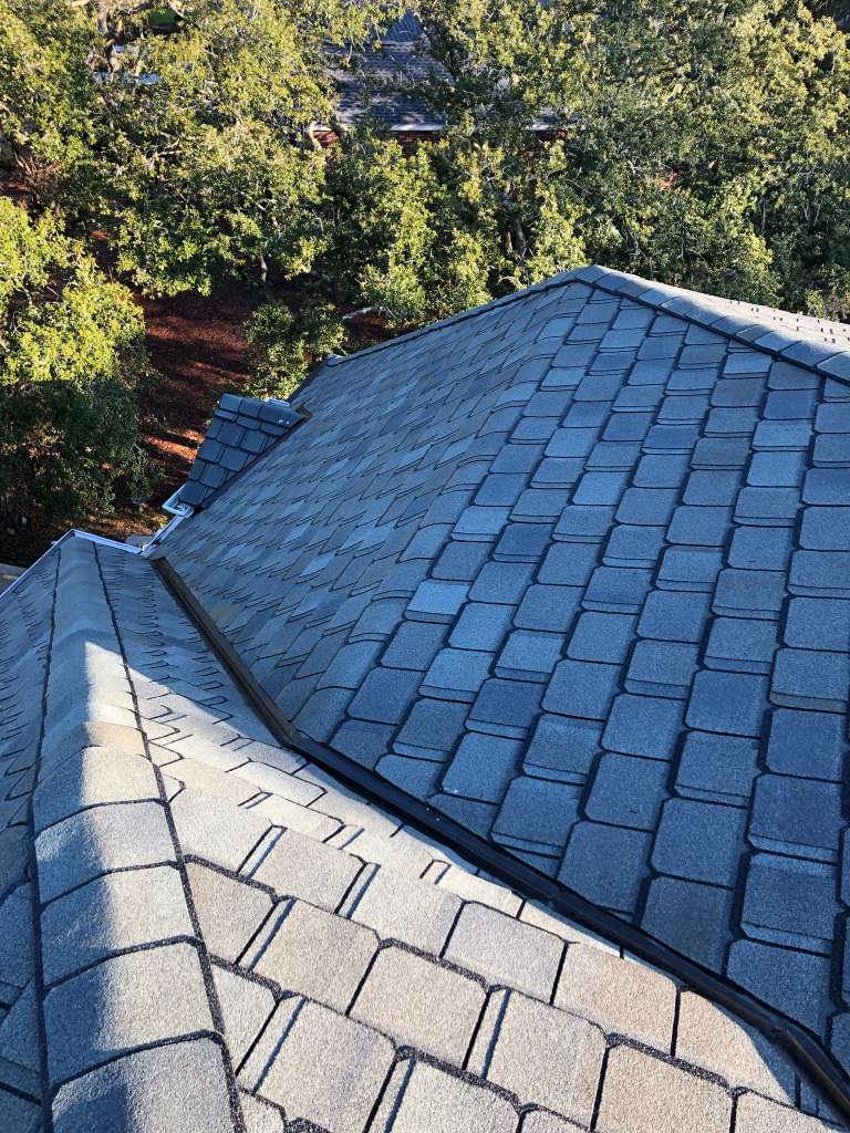 Experienced Austin TX roofing contractor Cuatro Pilares installing architectural shingle roof with precision flashing around chimney for long-lasting protection