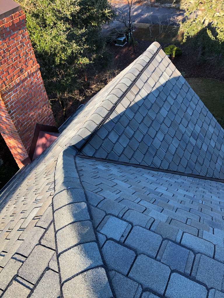 Experienced Austin TX roofing contractor Cuatro Pilares installing architectural shingle roof with precision flashing around chimney for long-lasting protection