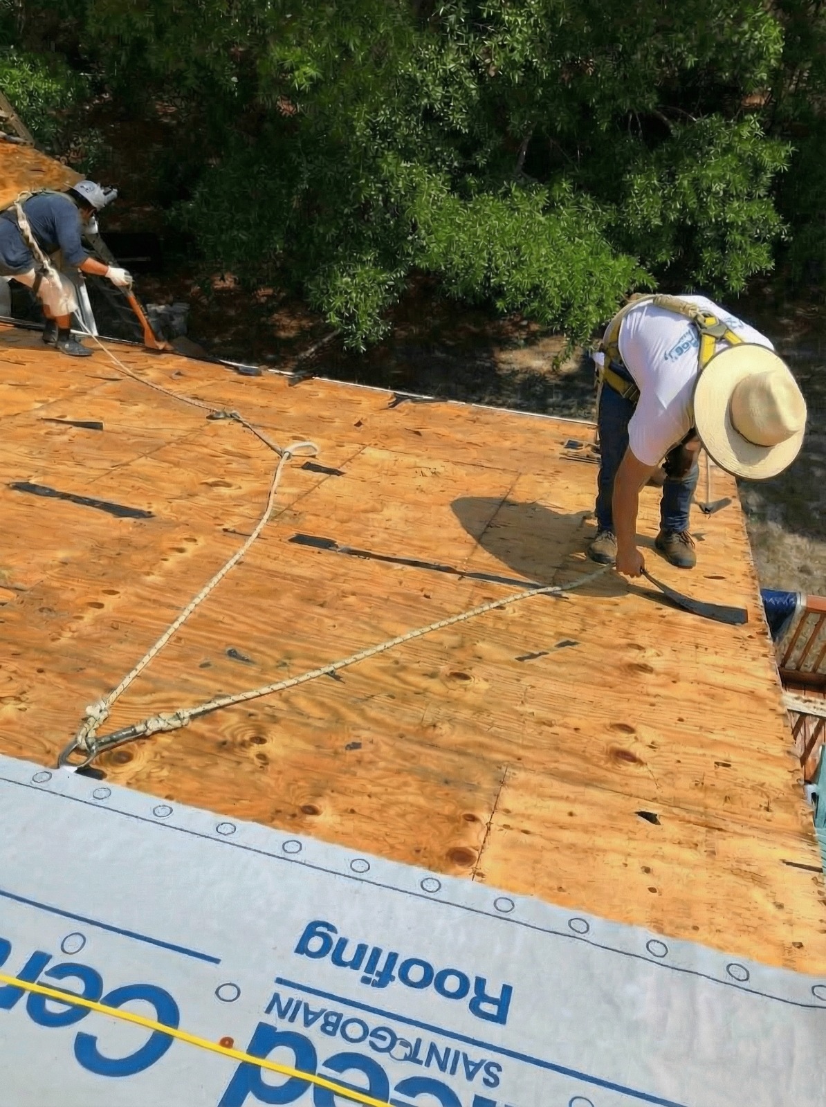 Experienced Austin TX roofing contractor Cuatro Pilares crew performing roof tear-off and preparing wood decking before installing new roofing system