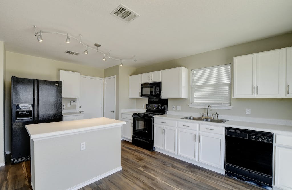 Experienced Cuatro Pilares team completing kitchen remodel in Austin TX with backsplash and cabinet installation