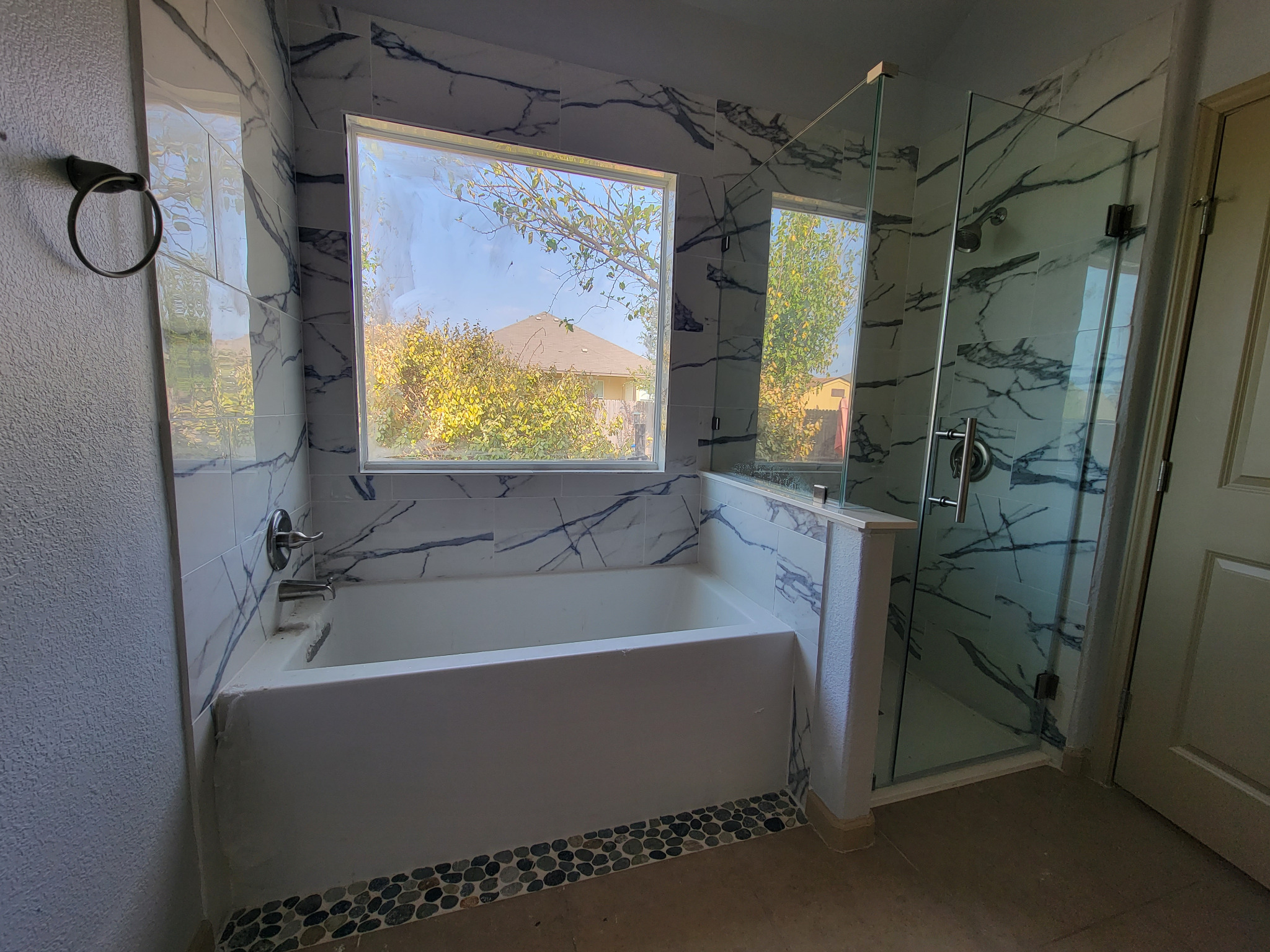 High-end bathroom renovation in Austin TX by Cuatro Pilares with soaking tub, glass shower, and custom finishes